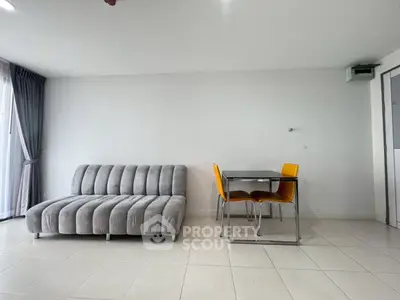 Modern living room with sleek gray sofa and stylish dining set