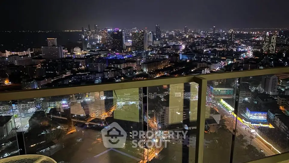 Stunning cityscape view from a high-rise balcony at night, showcasing vibrant city lights and skyline.