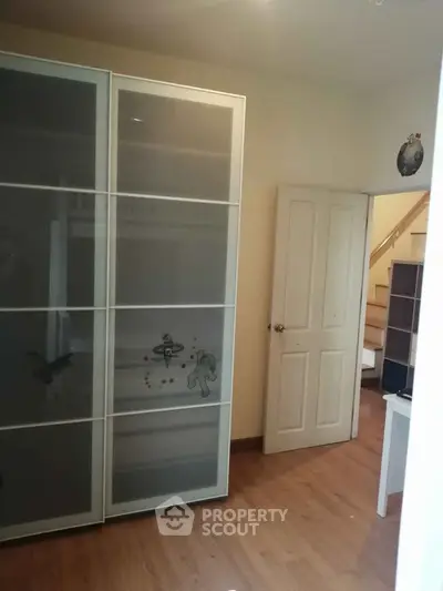Spacious bedroom with sliding closet doors and wooden flooring