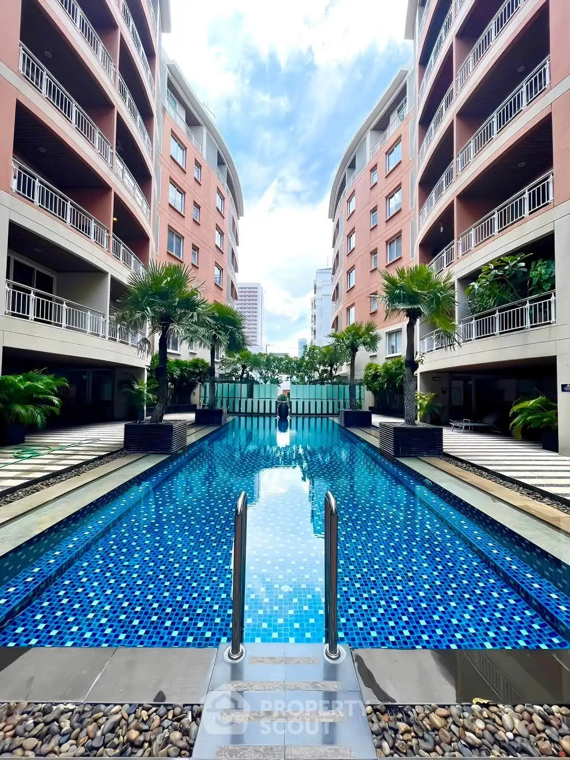 Luxurious apartment complex with stunning outdoor pool and modern architecture.
