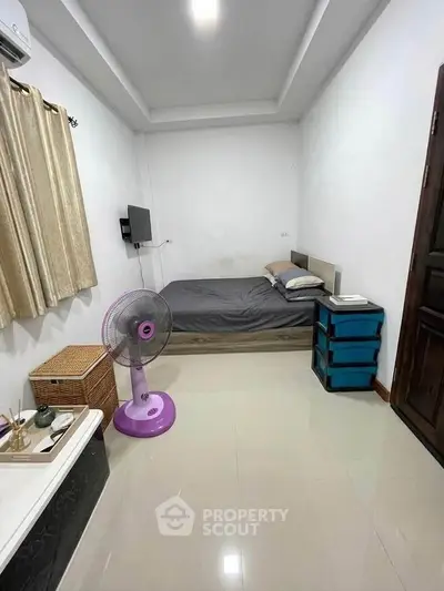 Cozy bedroom with modern decor, featuring a comfortable bed, fan, and ample storage space.