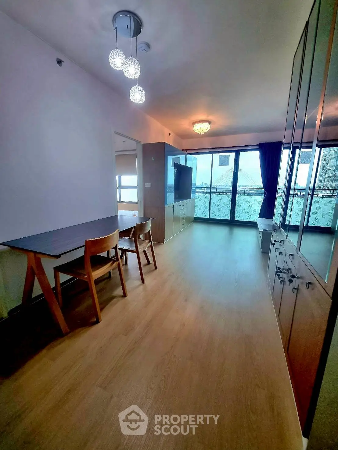 Spacious living room with modern lighting and large windows offering natural light.