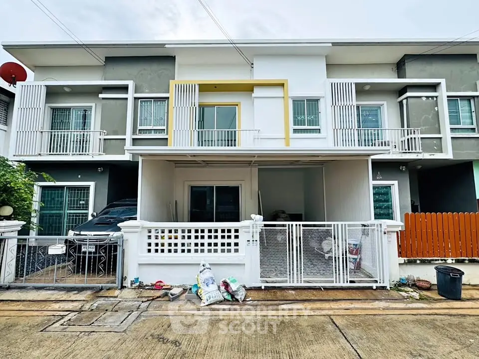Modern townhouse exterior with gated entrance and driveway parking