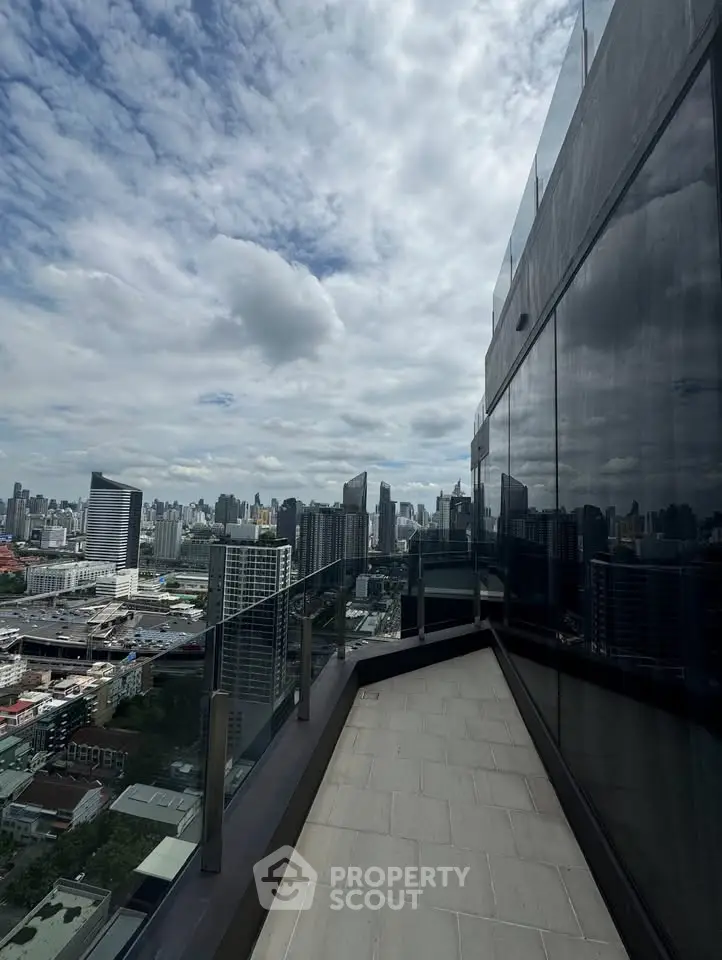 Stunning cityscape view from a high-rise balcony with modern glass railing and sleek building facade.