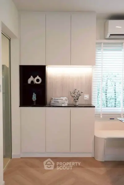 Modern living room with sleek cabinetry and stylish decor in a bright, airy space.