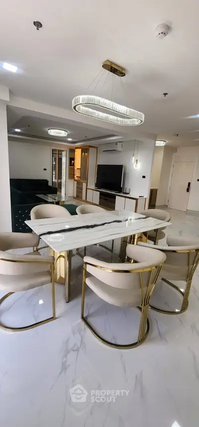 Luxurious dining area with elegant marble table and modern chairs in a spacious open-plan living room.