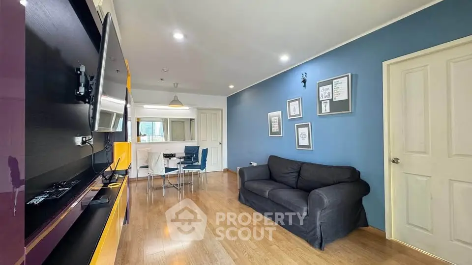 Modern living room with blue accent wall, cozy sofa, and stylish dining area.
