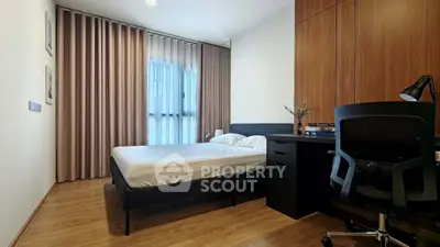 Modern bedroom with wooden flooring, sleek desk, and large window with curtains.