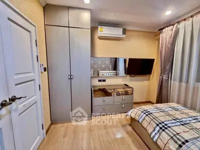 Cozy bedroom with modern decor, built-in wardrobe, and wall-mounted TV.