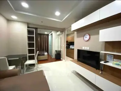 Modern open-plan living room with sleek furniture and integrated kitchen area.