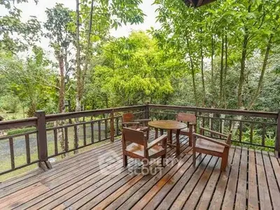 Charming wooden deck with outdoor seating amidst lush greenery, perfect for relaxation.
