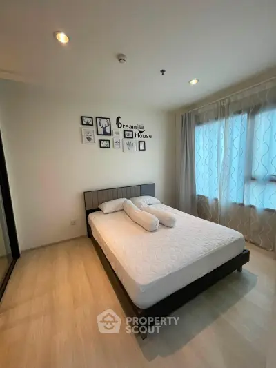 Modern bedroom with stylish decor and large window for natural light.