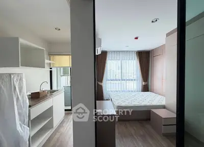 Modern studio apartment with open layout, featuring a cozy bedroom and compact kitchen area.