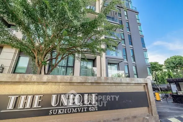 Modern condominium exterior with lush greenery at The Unique Sukhumvit 62/1.