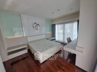 Spacious bedroom with modern decor and large windows for natural light.