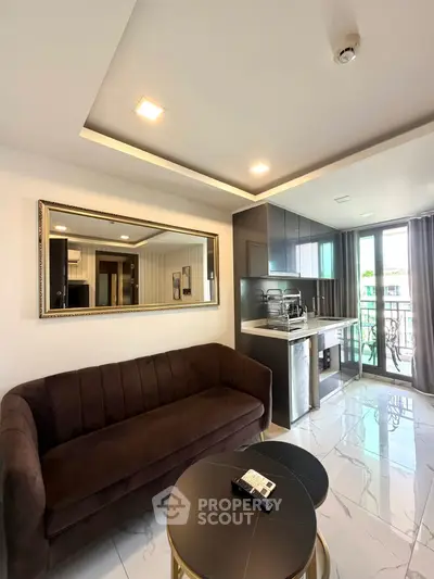 Modern living room with sleek kitchen and balcony view, featuring elegant decor and natural light.