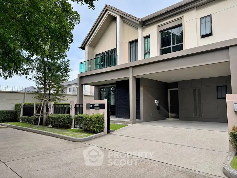 Modern two-story house with spacious driveway and lush greenery in a serene neighborhood.