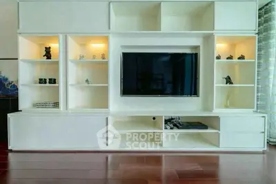 Modern living room with sleek built-in entertainment center and hardwood floors.