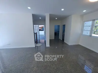 Spacious modern living room with glossy flooring and ample natural light.
