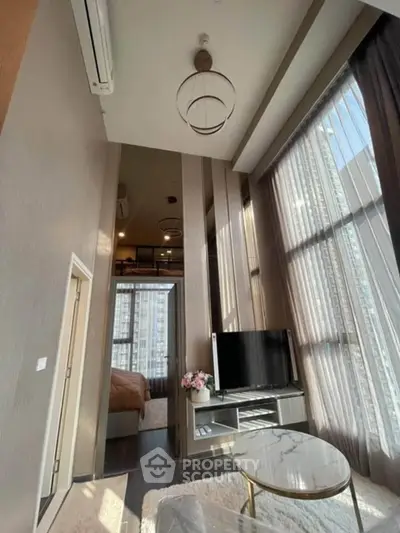 Luxurious high-ceiling living room with modern decor and large windows offering stunning city views.