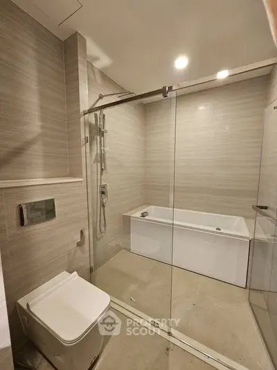 Modern bathroom with glass shower and bathtub in luxury apartment