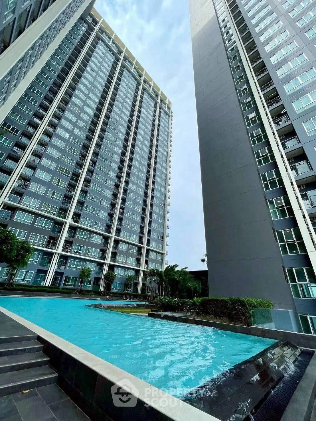 Modern high-rise buildings with a luxurious swimming pool in a vibrant urban setting.