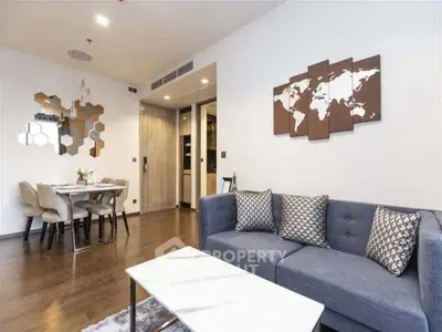 Modern living room with stylish decor and dining area, featuring a cozy sofa and elegant wall art.