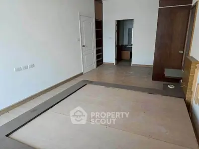 Spacious bedroom with wooden flooring and built-in closet, perfect for modern living.