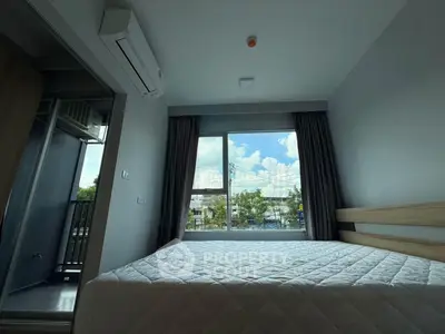 Modern bedroom with large window and air conditioning, offering a bright and comfortable living space.
