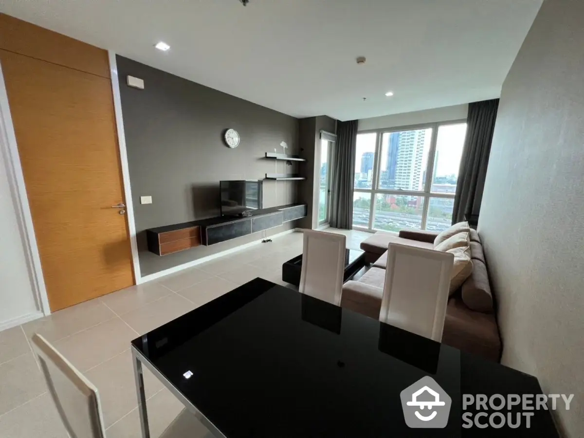 Modern living room with sleek furniture and large windows offering an urban view, perfect for comfortable city living.