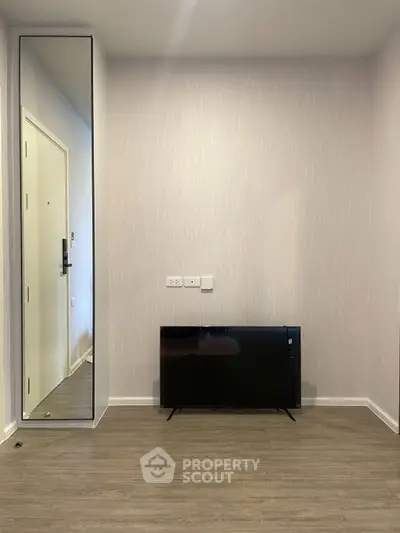 Modern minimalist living room with wall-mounted TV and sleek mirror design