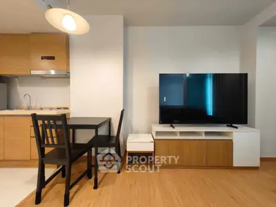 Modern living room with sleek TV setup and compact dining area