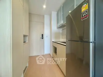 Modern kitchen with sleek appliances and ample storage in a stylish apartment.