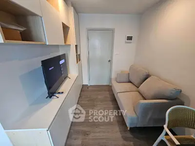 Cozy living room with modern furniture and TV, perfect for relaxation.
