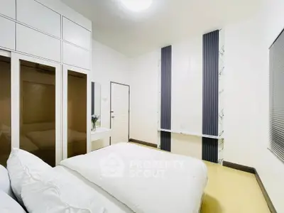Spacious modern bedroom with sleek design and ample storage space.