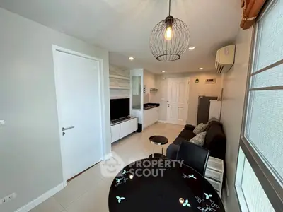 Modern living room with stylish decor, featuring a cozy sofa, sleek TV unit, and elegant lighting.