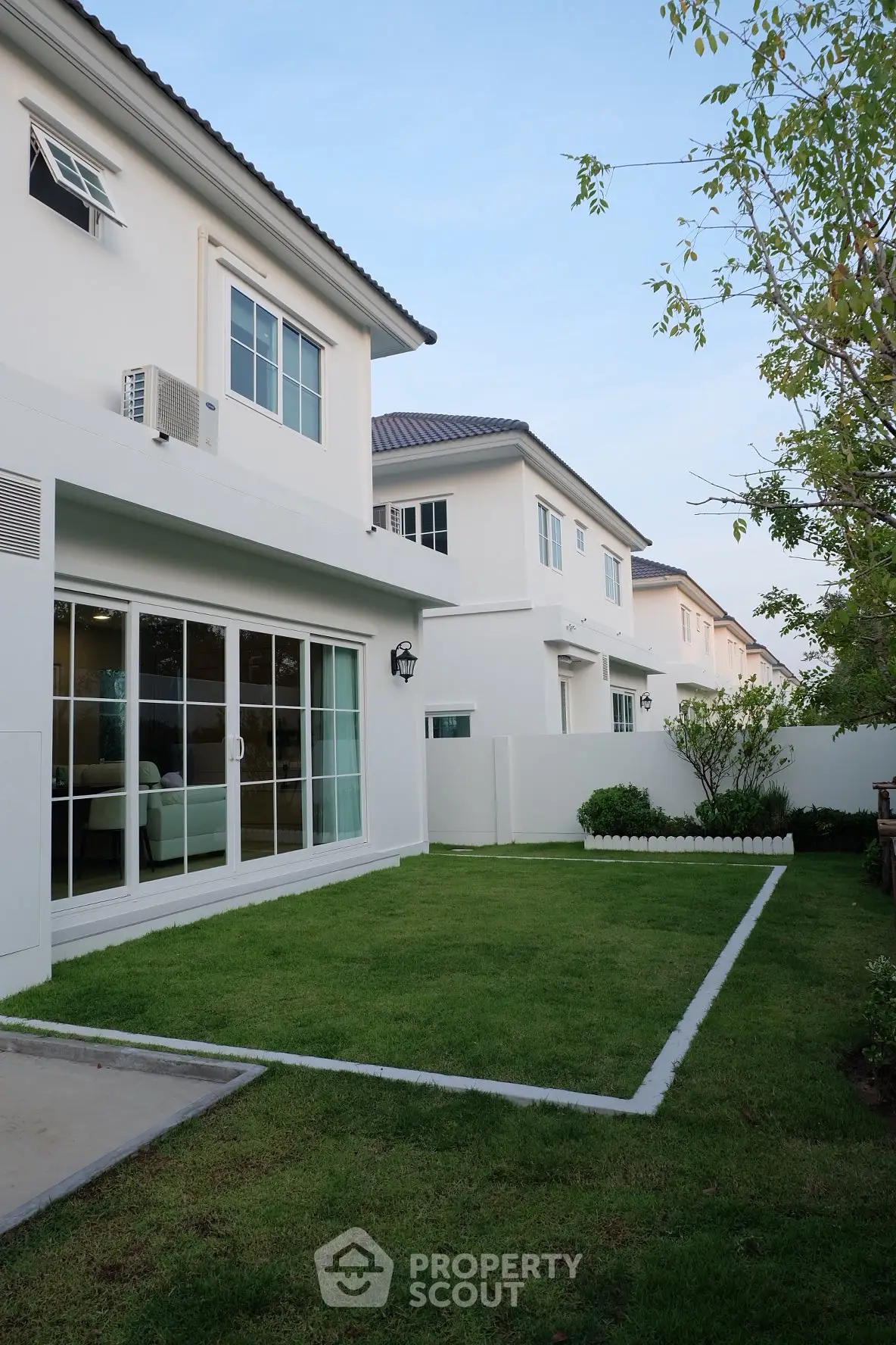 Modern suburban home with lush green lawn and spacious backyard, perfect for family living.