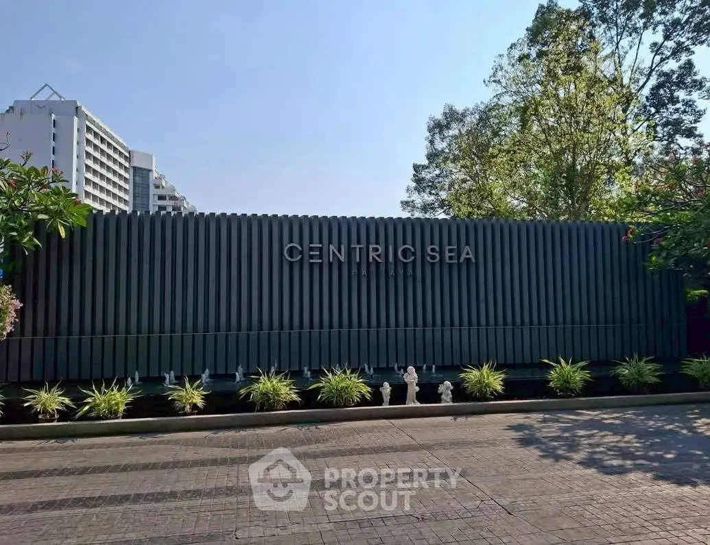 Modern building entrance with lush greenery at Centric Sea, ideal for urban living.