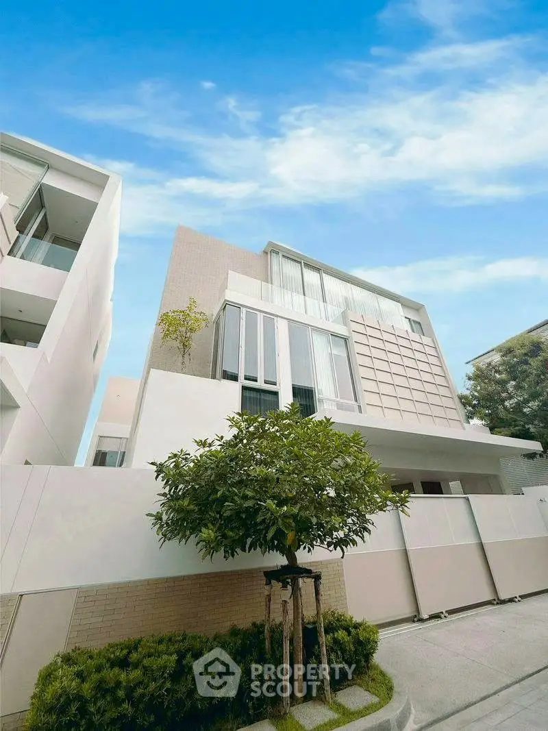 Modern luxury building with sleek design and lush greenery, perfect for upscale living.