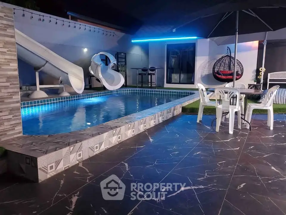 Luxurious modern pool area with slide and stylish seating, perfect for entertainment and relaxation.