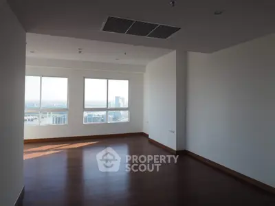 Spacious empty room with large windows and city view, perfect for customization.