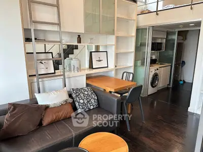 Modern loft apartment with stylish living area and compact kitchen featuring washing machine.