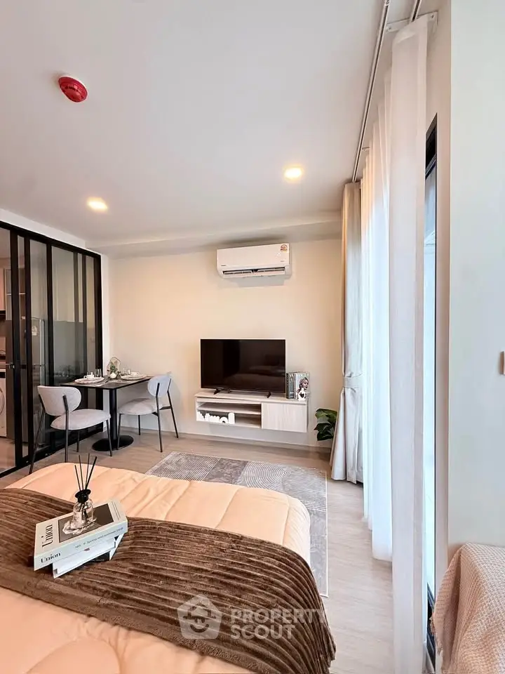 Modern living room with stylish decor and open layout, featuring a cozy dining area and sleek entertainment center.