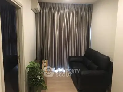 Cozy living room with black leather sofa and elegant curtains