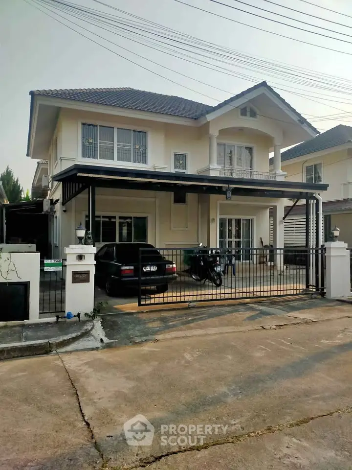 Charming two-story house with gated driveway and modern exterior design.