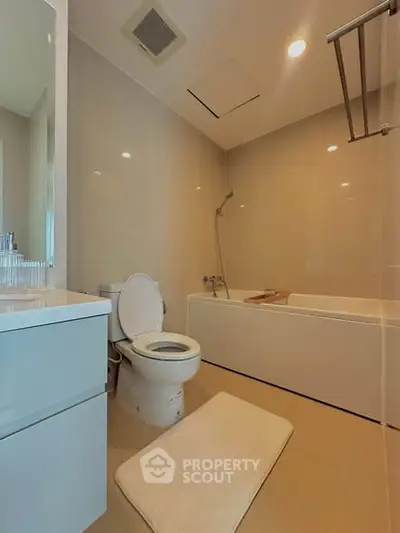Modern bathroom with sleek fixtures and a bathtub, offering a clean and minimalist design.