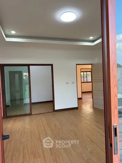 Spacious modern room with wooden flooring and sliding glass doors