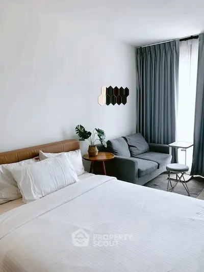 Modern bedroom with cozy seating area and stylish decor