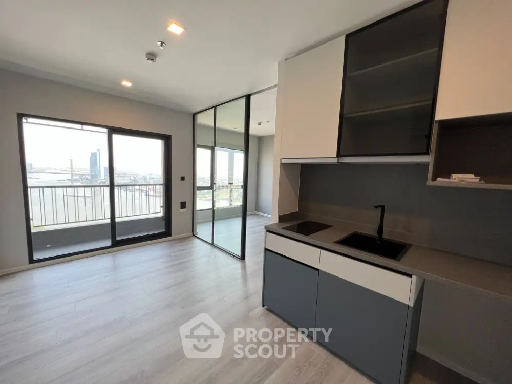 Modern apartment with open kitchen and spacious balcony offering stunning city views.