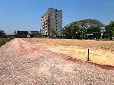 Expansive land plot with development potential near urban area, featuring clear skies and accessible road.